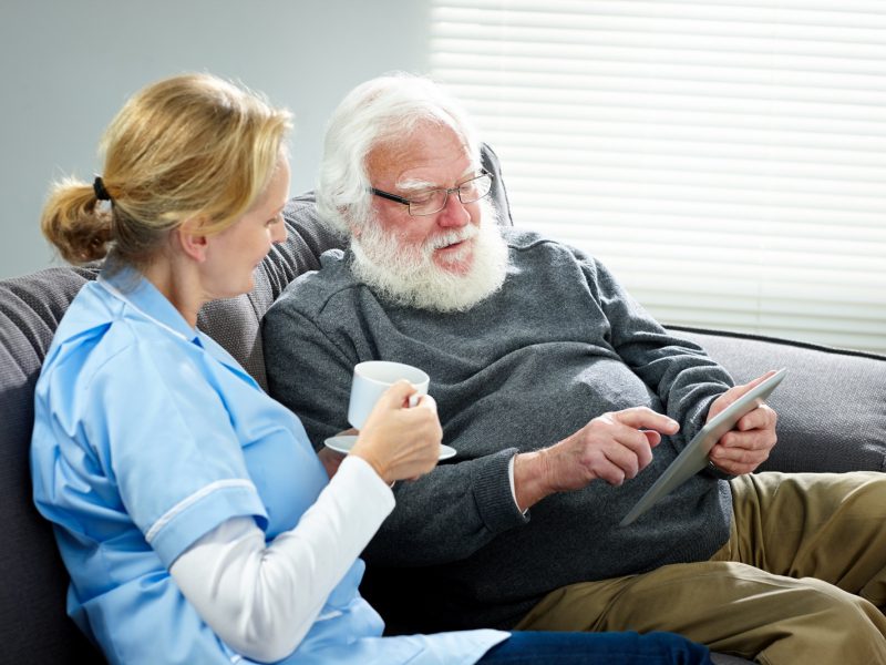 care worker with aged care resident and ipad